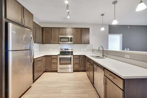 A modern kitchen with wooden cabinets and stainless steel appliances.