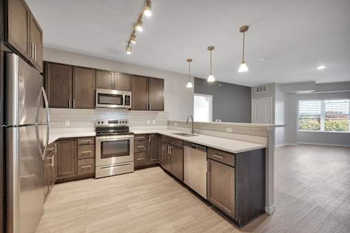 A modern kitchen with stainless steel appliances and wooden cabinets.