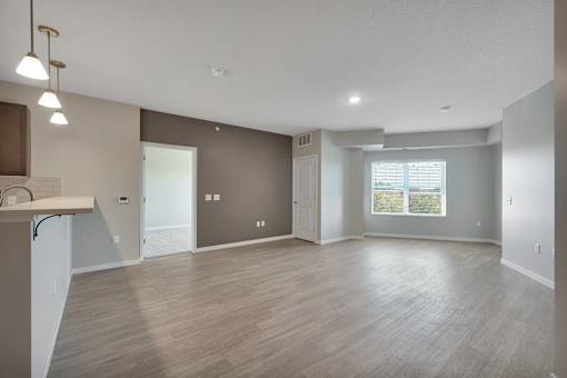 A spacious living room with a kitchenette and a view of the outdoors.