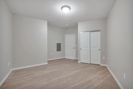 A room with a white door and a white closet.