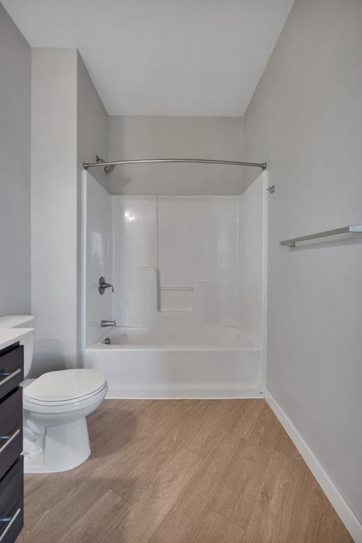 A white toilet sits next to a walk-in shower in a bathroom.