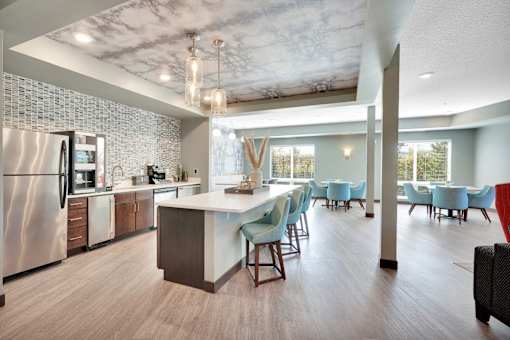 A modern kitchen with a dining area and a refrigerator.