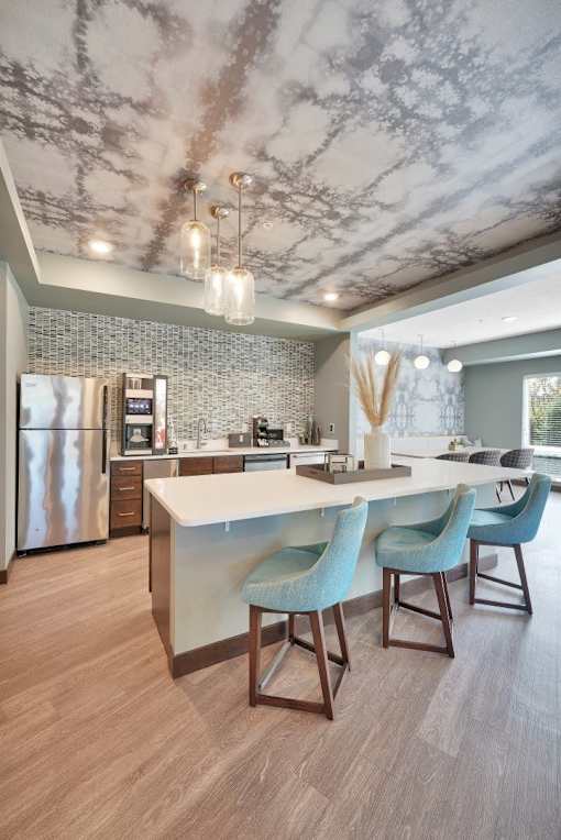 A modern kitchen with a marble ceiling and a central island.