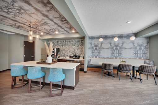 A kitchen with a bar area and blue chairs.