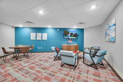 A room with a blue wall and a carpet with a red and beige pattern.