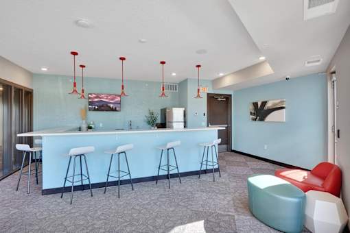 A bar area with white stools and a counter.