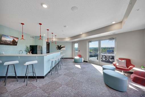 A modern bar area with a long counter and stools.