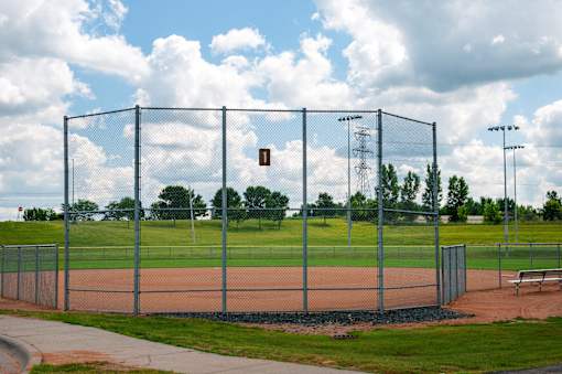 A baseball field is enclosed by a chain link fence.
