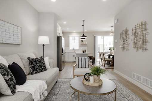 A living room with a couch, coffee table, and a large painting on the wall.