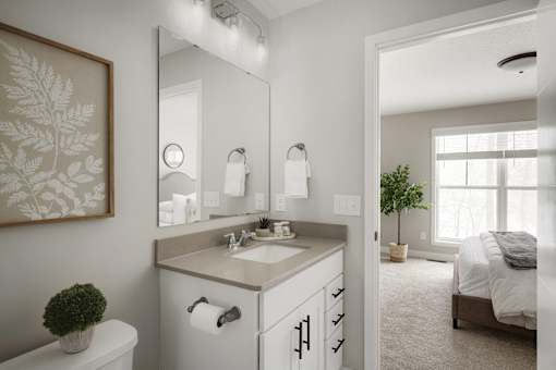 A bathroom with a toilet, sink, and mirror.