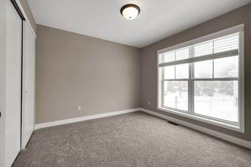 A room with a carpeted floor and a window.