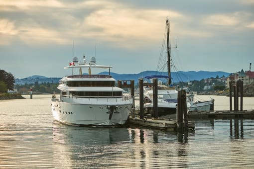 a large white yacht is docked next to a small white boat
