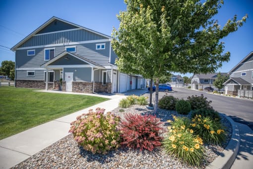 a tree in front of a house on a street at The Brix Apartments, Spokane Valley, WA, 99037