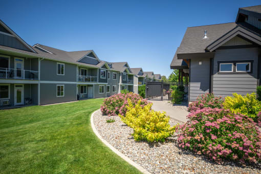 a house with a yard and landscaping in front of it at The Brix Apartments, Spokane Valley, 99037