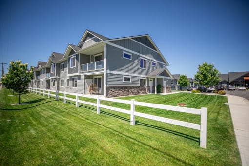 a house with a white fence in front of it at The Brix Apartments, Spokane Valley, WA, 99037
