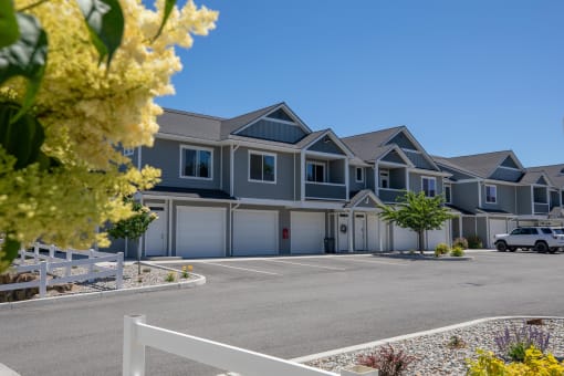 a row of houses on a street with a parking lot at The Brix Apartments, Spokane Valley, WA, 99037