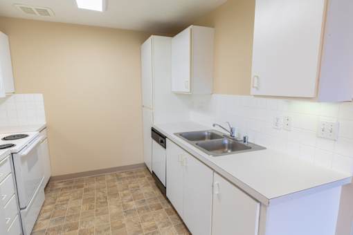 A kitchen with white appliances and cabinets.
