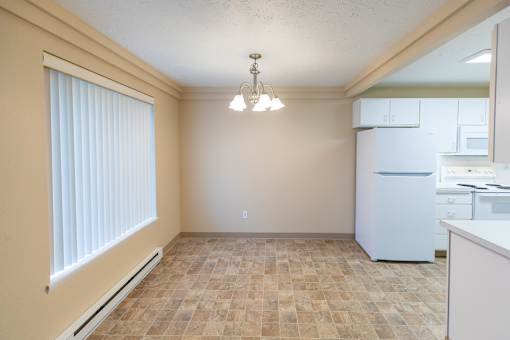 A kitchen area with a refrigerator, sink, and cabinets.