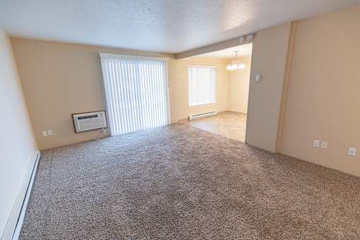 A sparsely furnished room with a window and a door.