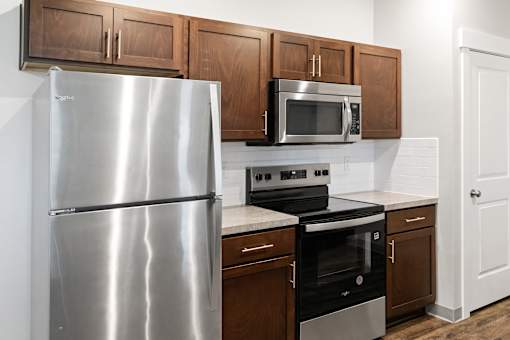 A kitchen with a stainless steel refrigerator, microwave, oven, and cabinets.at The Brix Apartments, Washington, 99037