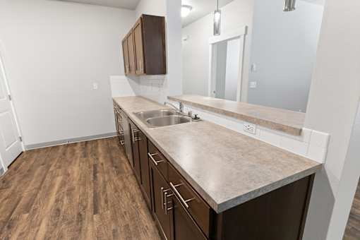 A kitchen with brown cabinets and a wooden floor.at The Brix Apartments, Spokane Valley, WA, 99037