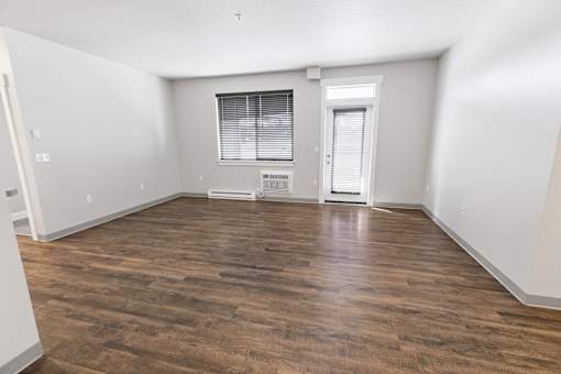 A room with wooden flooring and a window with blinds.at The Brix Apartments, Washington, 99037