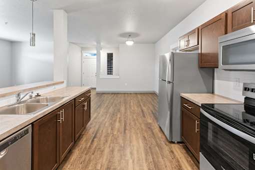 A kitchen with wooden cabinets and stainless steel appliances.at The Brix Apartments, Spokane Valley, Washington