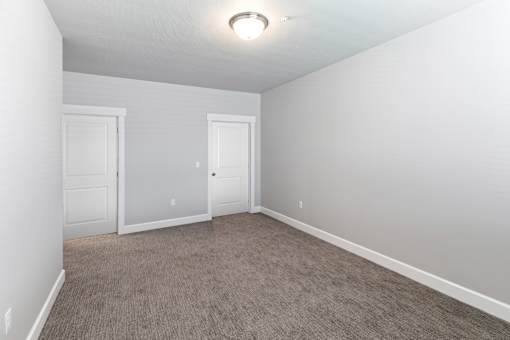 A room with two doors and carpeted floor.at The Brix Apartments, Washington