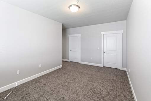 A room with two doors and carpeted floor.at The Brix Apartments, Spokane Valley, WA