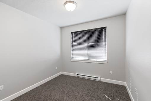 A room with a window and a carpeted floor.at The Brix Apartments, Washington, 99037
