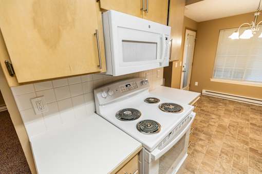A white stove and microwave in a kitchen at Graymayre Crossing Apartments, Spokane, WA, 99208