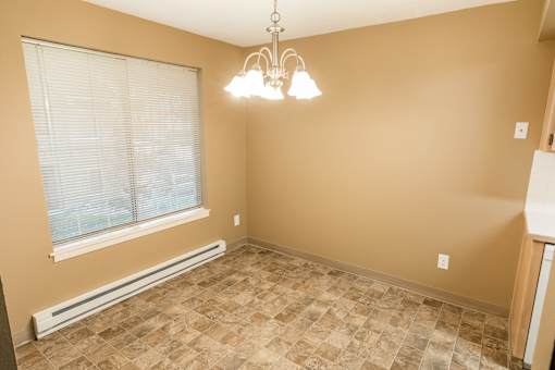 A room with a window, tiled floor, and a chandelier at Graymayre Crossing Apartments, Spokane, WA, 99208