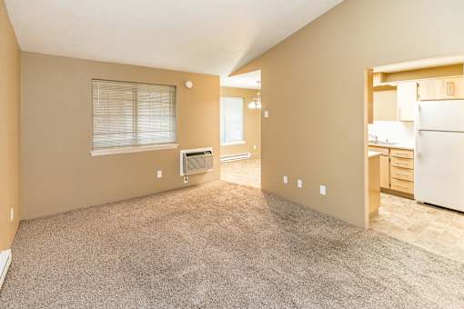 A spacious living room with a kitchen in the background at Graymayre Crossing Apartments, Spokane, 99208