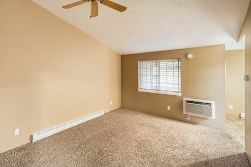 A room with a ceiling fan, window, and carpeted floor at Graymayre Crossing Apartments, Spokane, WA