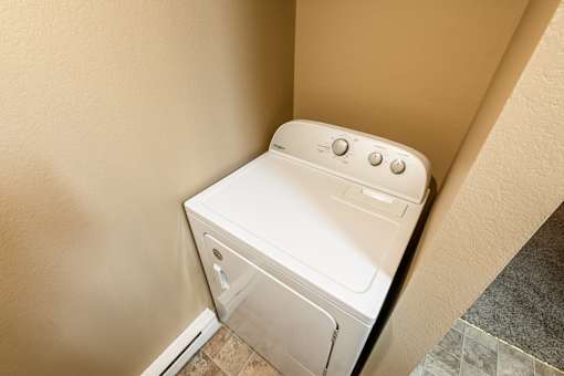 A white washing machine in a small space at Graymayre Crossing Apartments, Spokane, WA