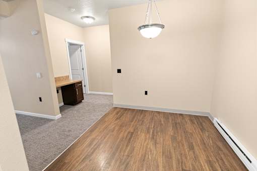 A room with a wooden floor and a hanging light fixture.