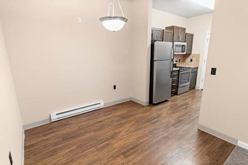 A kitchen with a refrigerator, microwave, and oven.