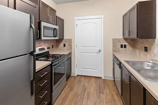 A kitchen with a white door and a white cabinet.