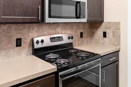 A modern kitchen with a stove top oven and microwave above it.