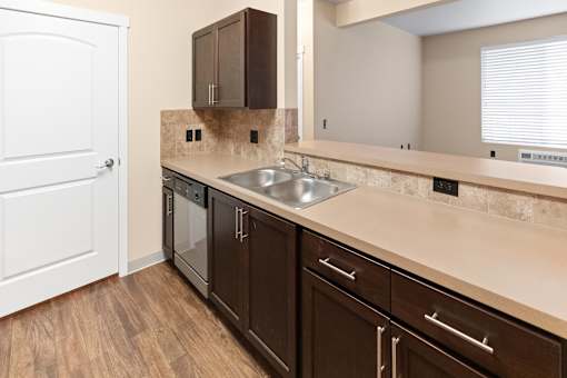 A kitchen with brown cabinets and a white door.