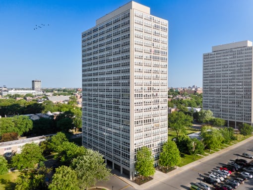 an aerial view of a tall skyscraper with two other skyscrapers in the background