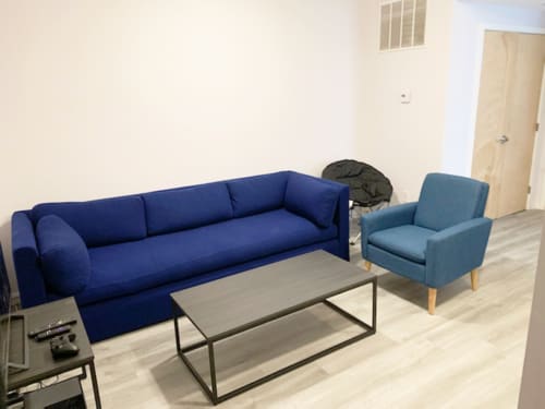 A blue sofa and matching chair are in a room with a coffee table.