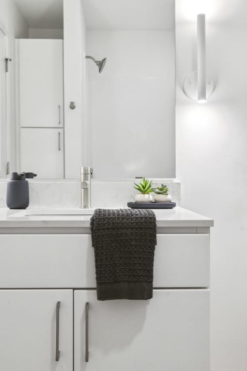 a white bathroom with a sink and a mirror
