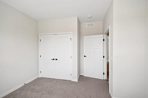 A room with a large closet and a carpeted floor  at Ironwood Townhomes in Medina, Minnesota.