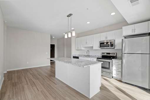 A modern kitchen with stainless steel appliances and a marble island.