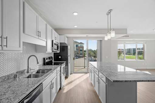 A modern kitchen with granite countertops and stainless steel appliances.