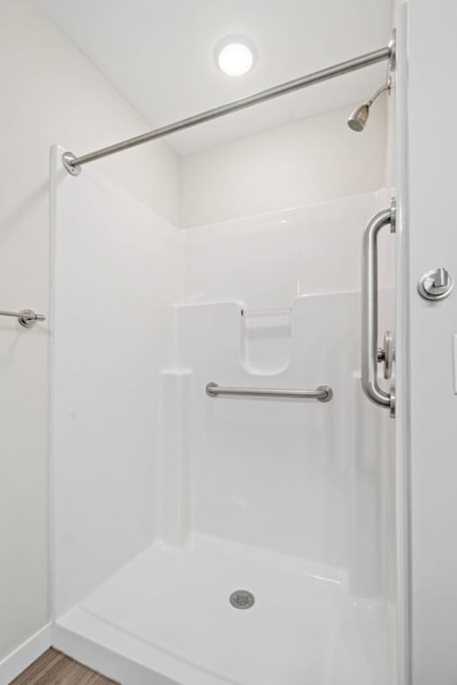 A white bathroom with a walk in shower.
