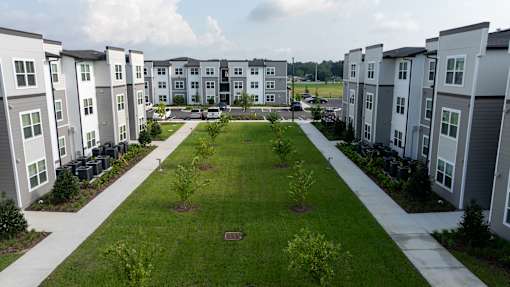 A view of a grassy area in front of apartment buildings.