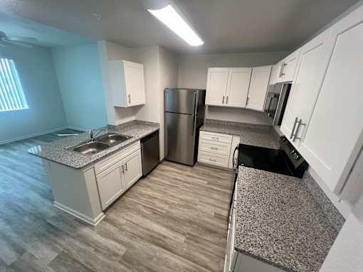 A kitchen with a granite countertop and a stainless steel refrigerator at Madison Highlands 2 Tampa Florida