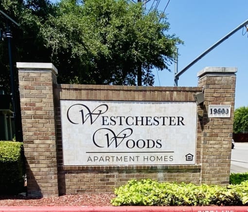 a sign apartment homes in front of a brick wall